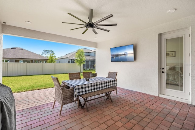 view of patio with fence, outdoor dining space, and ceiling fan
