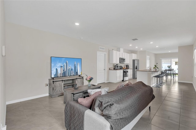 living area featuring recessed lighting, visible vents, baseboards, and light tile patterned floors