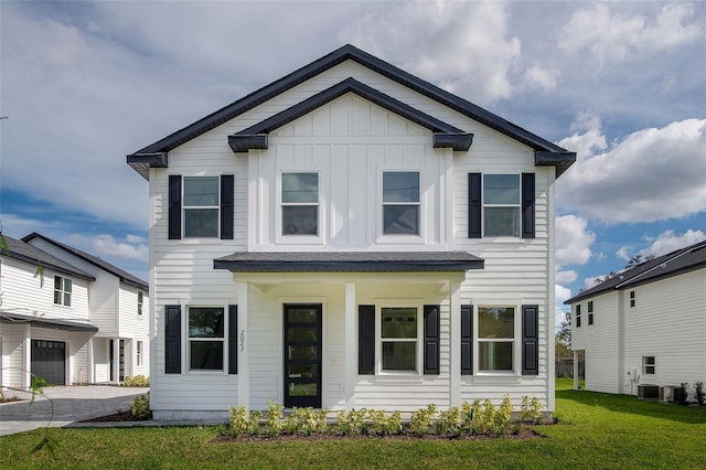 view of front of property with cooling unit, a garage, driveway, a front lawn, and board and batten siding