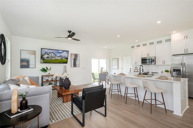 living area featuring ceiling fan, recessed lighting, and light wood-style floors