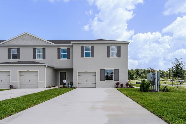 view of front of home featuring an attached garage, driveway, and a front lawn