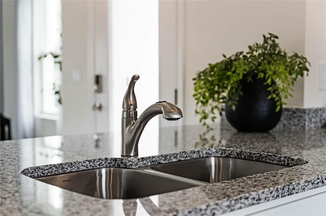 interior details featuring stone counters and a sink