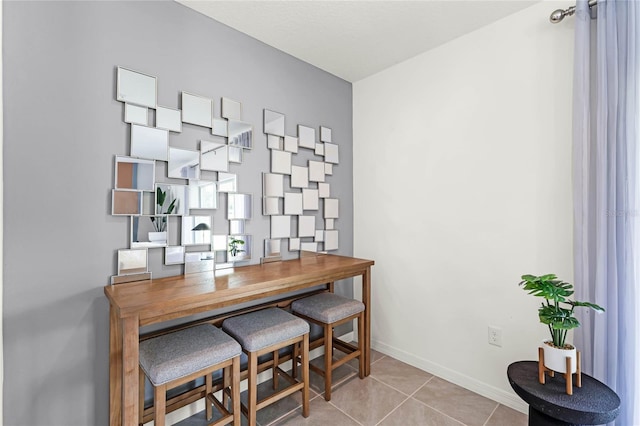 dining area with baseboards and tile patterned floors