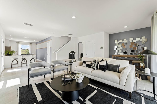 living room with light tile patterned floors, visible vents, and recessed lighting