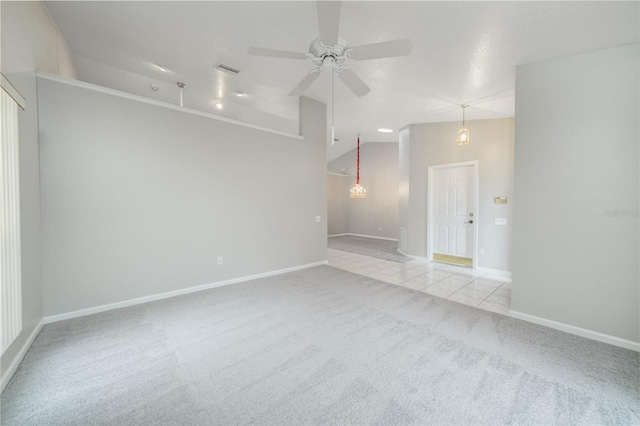 carpeted spare room with vaulted ceiling, ceiling fan, visible vents, and baseboards