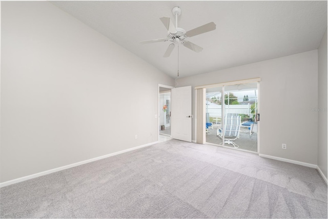 carpeted spare room featuring lofted ceiling, ceiling fan, and baseboards