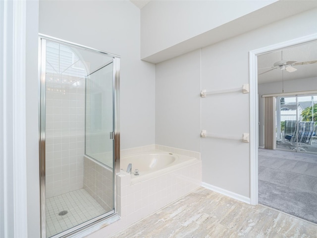 bathroom featuring ceiling fan, wood finished floors, baseboards, a shower stall, and a bath