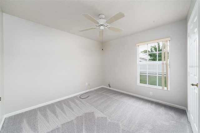 unfurnished room with carpet, a textured ceiling, baseboards, and a ceiling fan