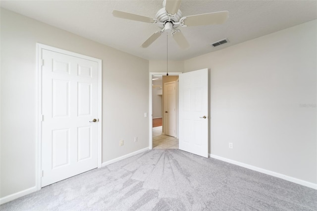 unfurnished bedroom with carpet floors, visible vents, a ceiling fan, a textured ceiling, and baseboards