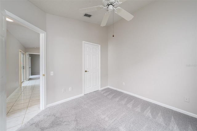 spare room with light carpet, visible vents, and baseboards