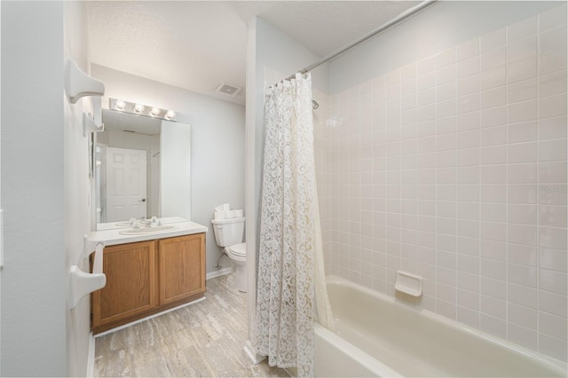 full bathroom featuring a textured ceiling, toilet, wood finished floors, vanity, and shower / bath combo