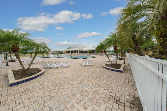 community pool featuring fence and a patio