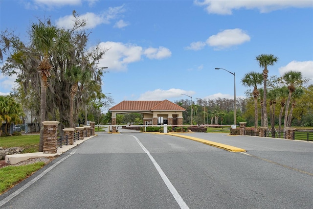 view of road with a gated entry and street lights