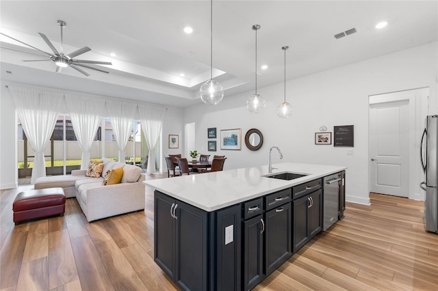 kitchen featuring dishwasher, light countertops, light wood-type flooring, and a sink