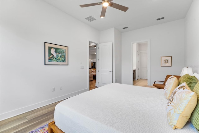 bedroom with ceiling fan, light wood finished floors, visible vents, and baseboards