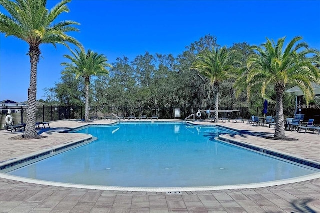 pool with a patio and fence