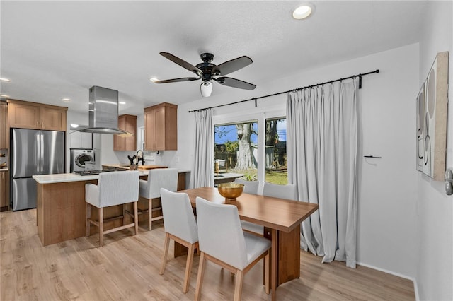 dining area featuring a ceiling fan, light wood-type flooring, stacked washer and clothes dryer, and recessed lighting