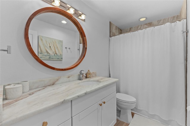 bathroom with toilet, curtained shower, and vanity