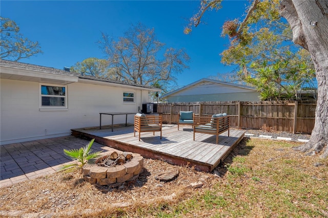 deck featuring central AC unit, a fire pit, a patio area, and fence