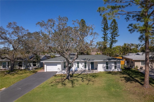 ranch-style home with aphalt driveway, an attached garage, and a front lawn