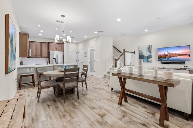 dining room with stairs, light wood-type flooring, visible vents, and recessed lighting