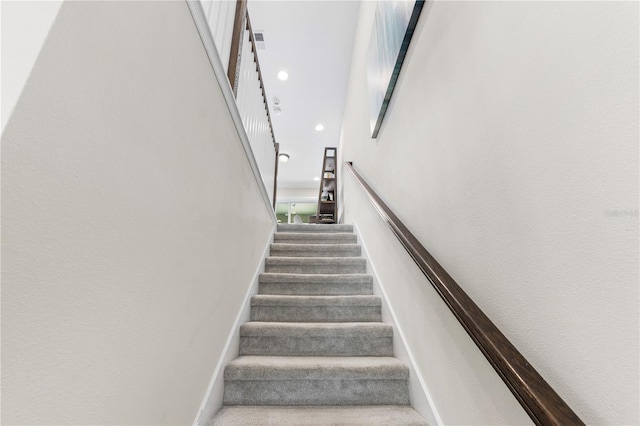 stairway featuring visible vents, baseboards, a towering ceiling, carpet, and recessed lighting