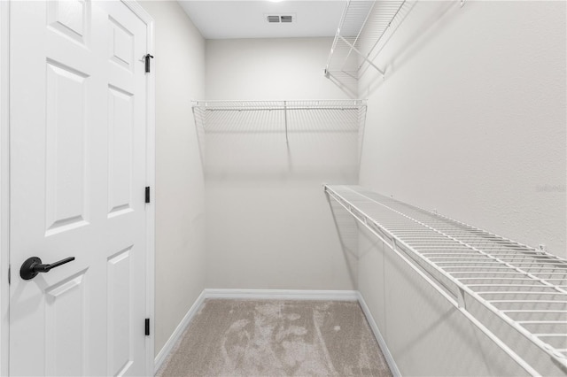 walk in closet with light carpet and visible vents