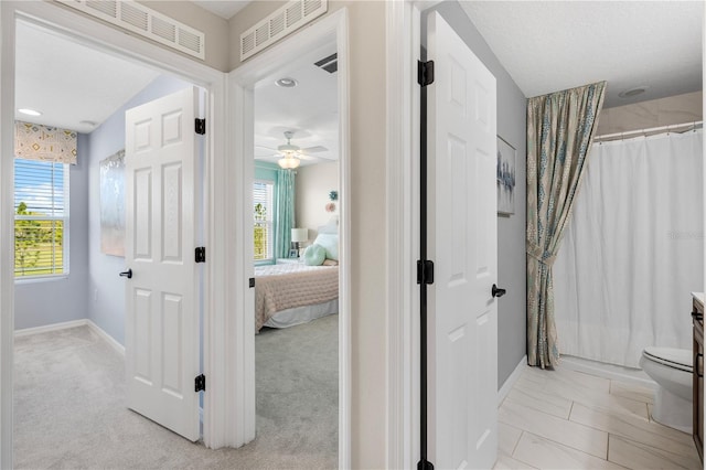 ensuite bathroom featuring plenty of natural light, visible vents, and ensuite bathroom