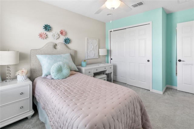 bedroom with a closet, visible vents, a ceiling fan, light carpet, and baseboards