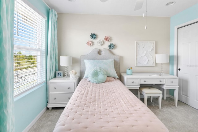 bedroom featuring light carpet and baseboards