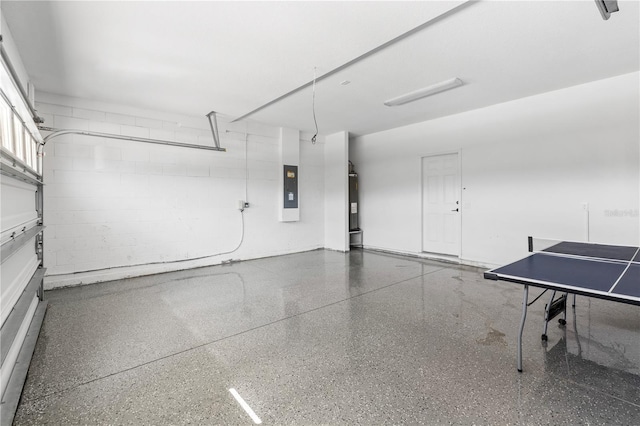 garage with water heater, concrete block wall, and electric panel