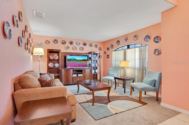 living room featuring visible vents, baseboards, and a textured ceiling