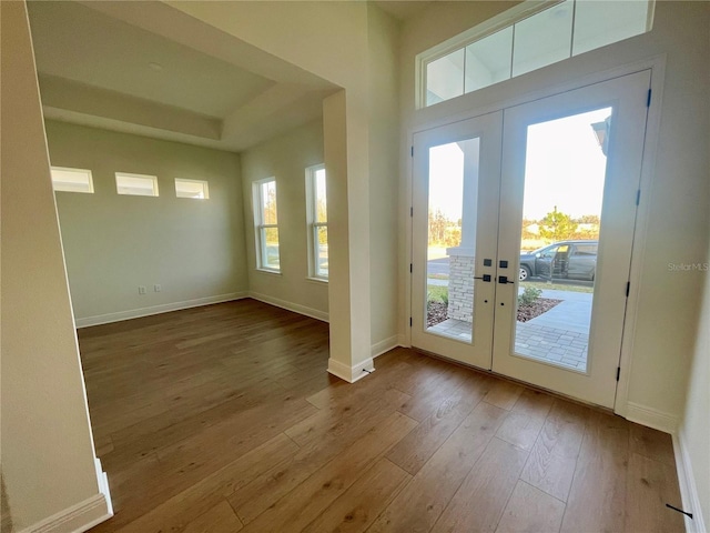 doorway with baseboards, hardwood / wood-style floors, and french doors