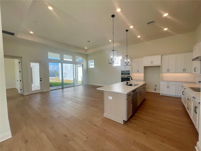 kitchen featuring stainless steel appliances, open floor plan, visible vents, and a raised ceiling