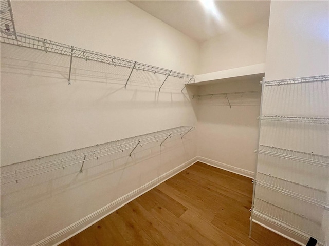 walk in closet with wood finished floors