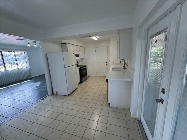 kitchen featuring white appliances, light tile patterned floors, light countertops, and a sink