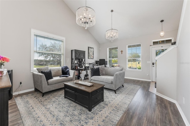 living area featuring baseboards, high vaulted ceiling, wood finished floors, and an inviting chandelier