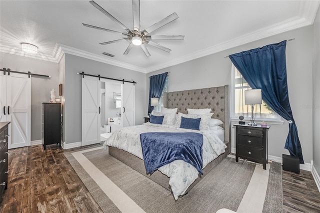 bedroom with a barn door, visible vents, wood finished floors, and ornamental molding