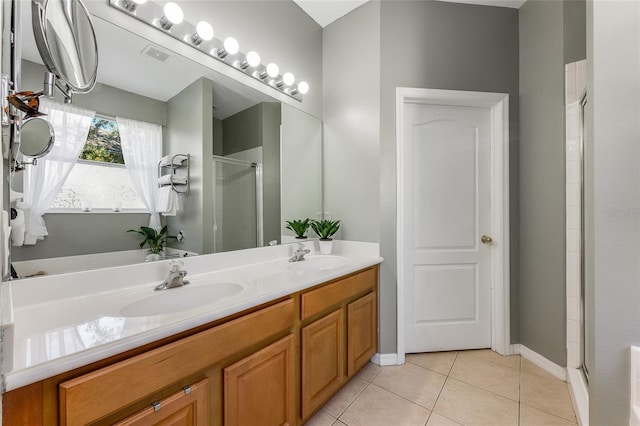 bathroom with double vanity, tile patterned floors, a sink, and a shower stall