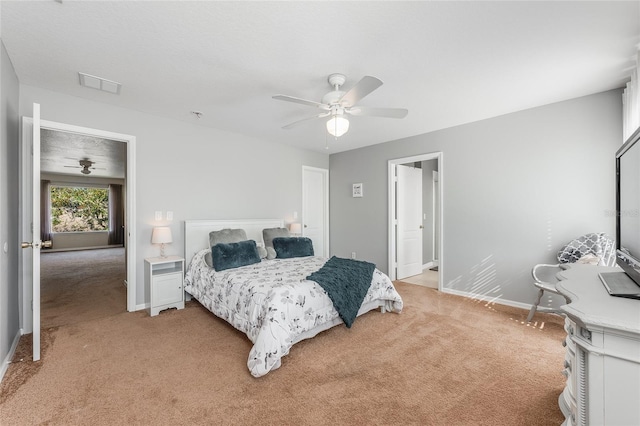 bedroom featuring baseboards, a ceiling fan, visible vents, and light colored carpet