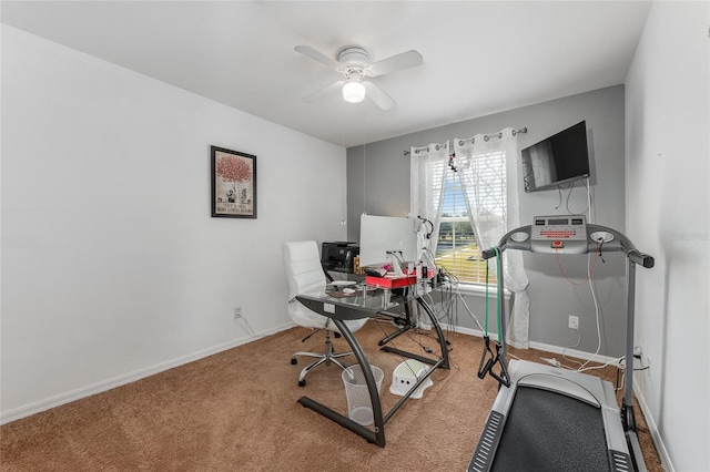 carpeted office space featuring ceiling fan and baseboards