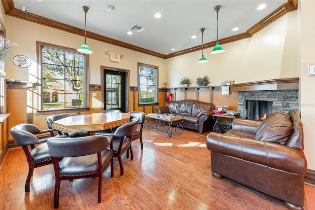 interior space featuring a fireplace, wood finished floors, visible vents, and crown molding