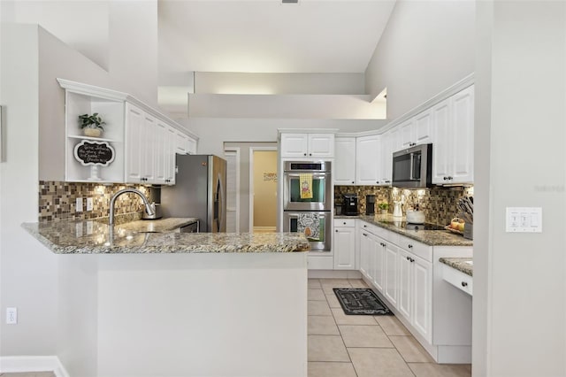 kitchen with open shelves, stainless steel appliances, light tile patterned flooring, a sink, and a peninsula