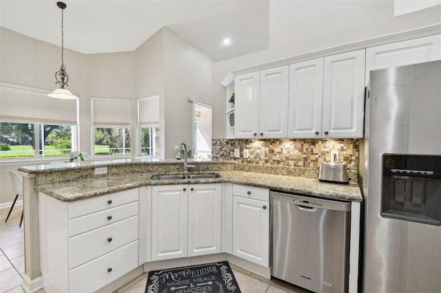 kitchen featuring stainless steel appliances, white cabinets, a sink, and decorative backsplash