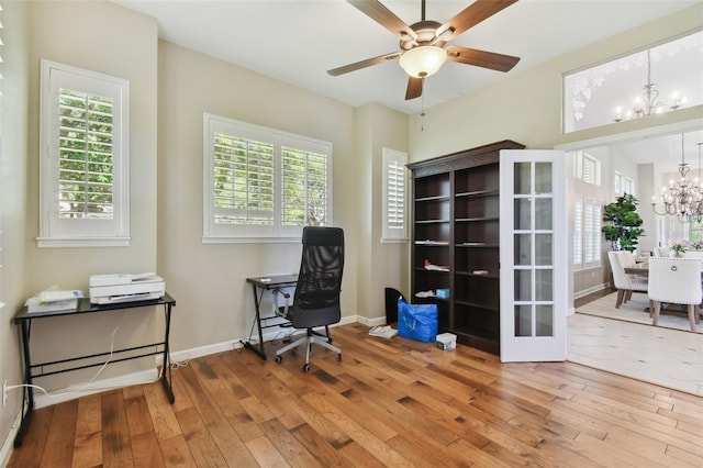 office area with wood-type flooring, baseboards, and ceiling fan with notable chandelier