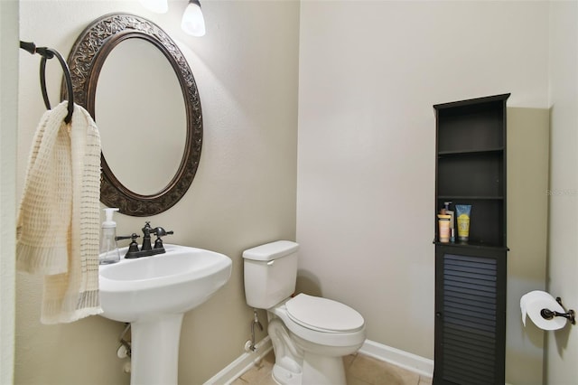 bathroom with toilet, tile patterned flooring, and baseboards