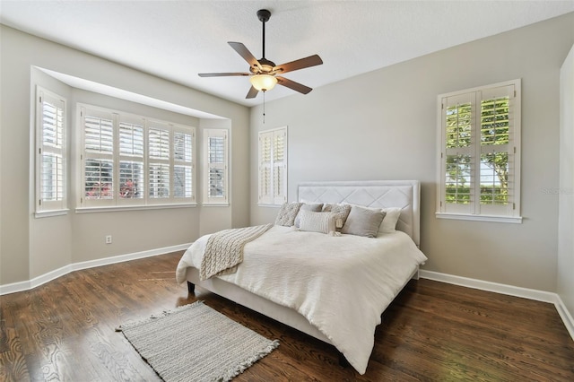 bedroom featuring ceiling fan, a textured ceiling, wood finished floors, and baseboards