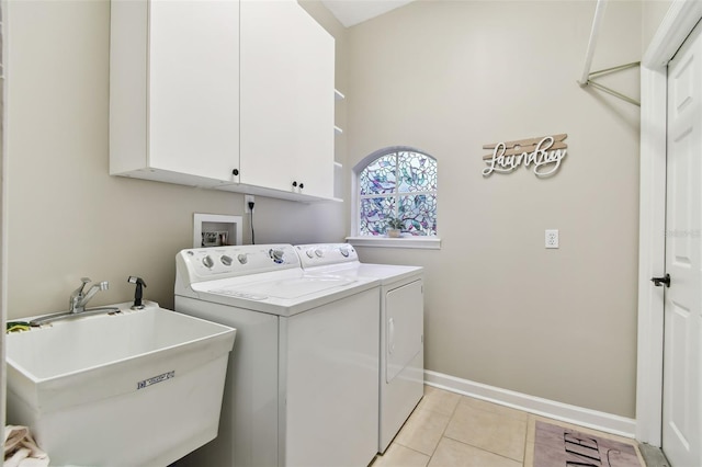 laundry room featuring cabinet space, baseboards, independent washer and dryer, a sink, and light tile patterned flooring