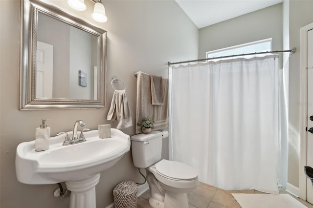 bathroom featuring a shower with shower curtain, a sink, toilet, and tile patterned floors