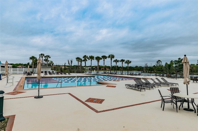 community pool with fence and a patio